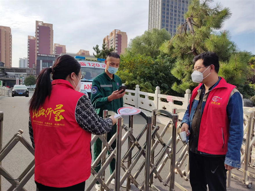 2022年10月28日，组织志愿者协助物业在单位入口处协助物业开展疫情防控工作，严格控制人员车辆出入。图为志愿者检查外来人员双码.jpg